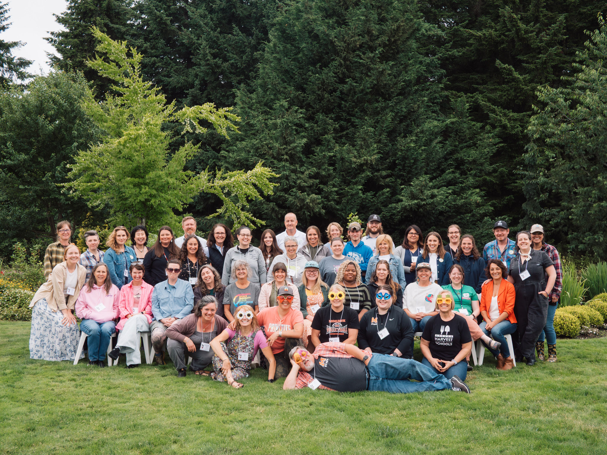 A large group of farm to school practitioners gather for an outdoor group photo