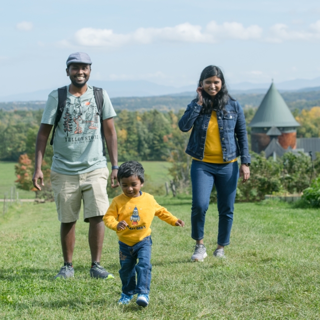 Couple with child on hill behind Farm Barn