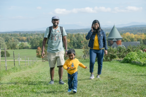 Two parents with child on walking trails behind the Farm Barn